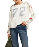 Remera color crema de manga larga con estampado del número 72 en el frente y bordados florales en mangas y hombros.