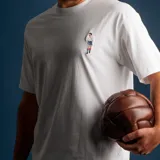 Remera blanca de algodón de alto gramaje con bordado en el pecho de un jugador de fútbol.