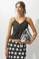 Top negro con tirantes finos, escote en V y detalle de nudo en el centro.