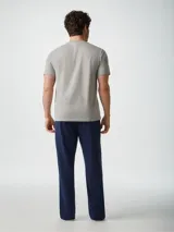 Pijama gris compuesto por una remera de manga corta con cuello redondo y un pantalón largo. La remera tiene un pequeño bordado en el pecho.