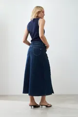 Maxi falda de jean azul oscuro, con tajos y botones dorados.