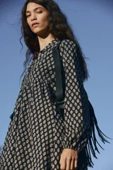 Vestido corto evasé de algodón liviano, color negro con estampado floral en tonos beige. Tiene cuello mao, abertura en V con tiras finas con borlas, mangas globo largas con elástico en los puños y cintura fruncida.