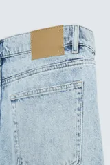 Pantalón de jean celeste de corte recto, con cinco bolsillos, efecto lavado y cierre frontal con botones.