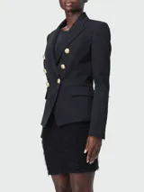 Blazer negro entallado de Balmain con doble botonadura y seis botones dorados.