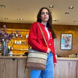 Bandolera de simil cuero color beige con paneles combinados en marrón y blanco. Tiene apertura superior con cierre, bolsillo frontal con cierre, tres bolsillos internos (dos con cierre) y un bolsillo trasero con cierre. Incluye correa larga regulable.
