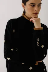 Sweater crudo de tejido de punto con cuello alto con volados y bordados de símbolos de naipes.