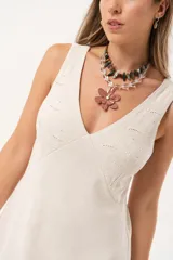 Vestido largo color beige de lino imperial, con escote en V, espalda con tirantes anchos y bordados en la parte superior. Tiene tajos a ambos lados.