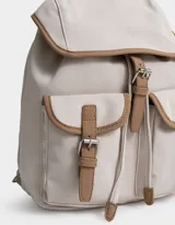 Mochila azul marino con detalles en cuero sintético color camel. Tiene solapa superior con cierre de hebilla, doble bolsillo frontal con hebilla, correa de ajuste y manija superior.