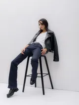 Chaqueta biker negra de cuero sintético con cierre asimétrico, cuello con solapas y tachas plateadas.