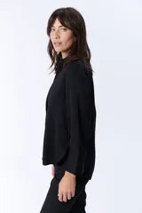 Camisa negra de manga larga con cuello clásico y cierre frontal con botones.