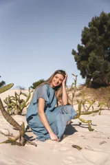 Vestido celeste de lino con mangas cortas y falda midi con volados de seda.