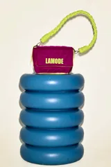 Cartera bandolera fucsia con patrón acolchado y ribete amarillo neón. Tiene asa corta trenzada color verde neón y logo "LAMODE" estampado en amarillo neón.