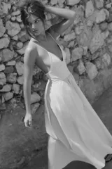 Vestido midi color crema de popelín, con escote en pico, tirantes finos ajustables, bolsillos laterales ocultos y detalle de pliegues. Incluye forro interior.