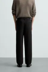 Pantalón de vestir color blanco hueso, de corte recto y tiro medio, con cintura elástica y cierre frontal de botón y cremallera. Presenta bolsillos frontales y bolsillos traseros de vivo.