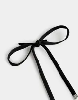 Collar corto de perlas sintéticas con dije de rosa metálica plateada y cierre de cinta de terciopelo negro.