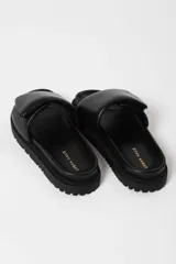 Sandalias negras con plataforma y tira ancha acolchada sobre el empeine.