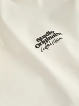 Camiseta color crema de manga corta y cuello redondo con estampado abstracto en la espalda.