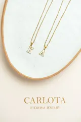 Collar con dije de letra inicial en acero quirúrgico con baño de oro 18k y cadena dorada fina.