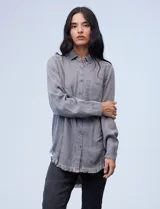 Camisa de tencel azul con cuello con solapa, escote en V y ruedo desflecado, de la marca Hester & Orchand.