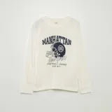 Conjunto de pijama largo de punto, compuesto por una remera blanca de manga larga con estampado de casco de fútbol americano y un pantalón azul marino liso.