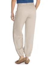 Pantalón de lino color beige, tiro alto, corte ancho, con bolsillos laterales y elástico en los tobillos.
