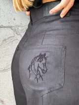 Pantalón sastrero color beige de lino, corte recto y tiro alto, con bordado de caballo en el bolsillo trasero.