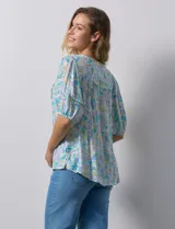 Blusa de gasa estampada con cuello en V, mangas cortas abullonadas con puño y terminación anudada en la parte delantera.