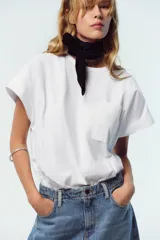 Camiseta blanca de algodón con cuello redondo, manga corta y bolsillo de plastrón en el delantero.