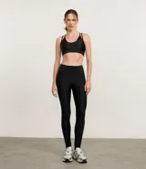 Top deportivo color tostado, confeccionado en microfibra con efecto satinado. Presenta copas y correas dobles ajustables.