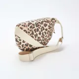 Riñonera con estampado animal print de leopardo en tonos marrón y beige. Tiene correa ajustable de algodón color crudo y cierre superior con cremallera.