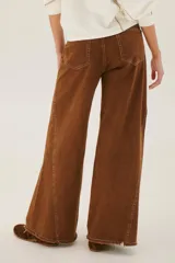 Pantalón de jean acampanado color caramelo con cintura alta y cinturón marrón con tachas.
