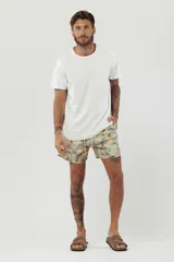 Short de baño con estampado de hojas de palmera en tonos beige, verde y naranja.