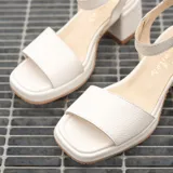 Sandalias de cuero color marrón con plataforma y tacón cuadrado. Tiras anchas sobre los dedos y tobillo con hebilla ajustable.