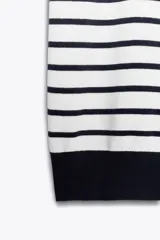 Top de punto color blanco con rayas horizontales azul marino, cuello redondo y manga corta.