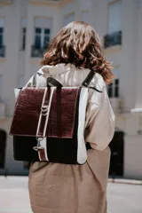Mochila y cartera de diseño clásico, con una combinación de colores blanco, negro y burdeos.