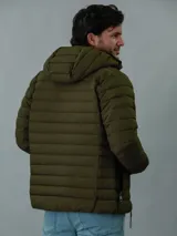 Campera acolchada verde militar con capucha, cierre frontal con cremallera y bolsillos laterales con cremallera.