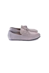 Mocasín gris de cuero gamuzado con lazo frontal y detalle de pasacintas laterales. Suela flexible antideslizante.