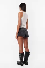 Short de jean negro de tiro medio con detalle de alegoría en bolsillos traseros. Cintura con pasacintos, cartera de cierre y botón metálico personalizado. Dos bolsillos delantero con relojero y remaches y dos bolsillos clásicos traseros. La prenda lleva proceso artesanal de lavado en toda la prenda.