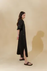 Vestido largo color beige, confeccionado en lino, con escote en V con volados y apliques de puntilla en las mangas. Posee bolsillos delanteros y tajos laterales.