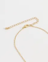 Collar corto dorado con cadena de eslabones y cuentas, con dijes colgantes de corazones, perlas y strass.