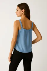 Musculosa blanca de bretel fino, cuello en V profundo y corte holgado.