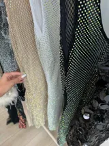 Vestido corto de fiesta con escote en V, confeccionado en tela de strass tornasolado y forro interior de tul alicrado a tono.
