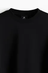 Buzo negro de corte holgado, con cuello redondo y mangas largas.