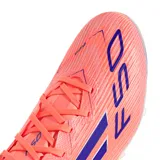 Championes de fútbol Adidas F50 League FG/MG, color naranja coral con tres franjas laterales en azul oscuro y el número "50" estampado en la puntera. Poseen tapones moldeados en la suela.