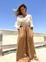 Pantalón palazzo color marrón claro, de tiro alto y corte amplio.