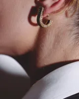 Par de aros tipo argolla gruesa, color dorado con incrustaciones de strass.