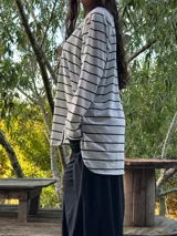 Remerón negro de manga larga, corte oversize con espalda más larga, tajos laterales y bajo redondeado.