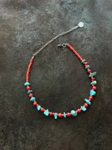 Collar corto con cuentas de coral natural color rojo, escallones turquesas y mostacillas. Se cierra con cadena de acero quirúrgico y ganchito para regular el largo.
