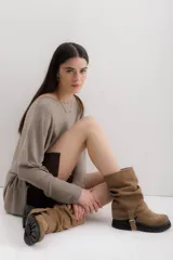 Bota de caña media color marrón claro, de gamuza con efecto arrugado, suela track y detalle de tira lateral con hebilla.