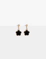 Aros colgantes cortos con pasante redondo dorado y dije de flor esmaltada negra con borde dorado.